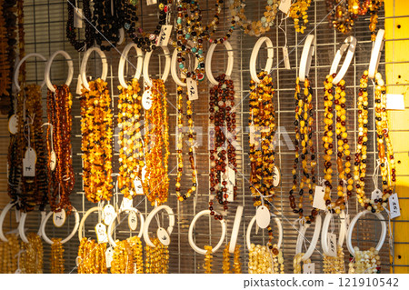 Amber stones market, polished orange gemstones closeup, natural Baltic amber gems jewelry store Amber stones market, polished orange gemstones closeup, natural Baltic amber gems jewelry store 121910542