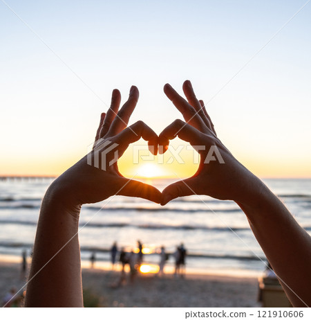 Hands gesture, love you sign at beach sunset, romantic emoji and happiness at ocean holiday 121910606