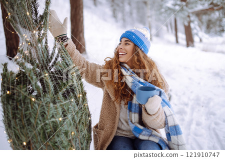 Smiling woman enjoying the Christmas atmosphere outdoors. Vacation concept. Smiling woman enjoying the Christmas atmosphere outdoors. Vacation concept. 121910747