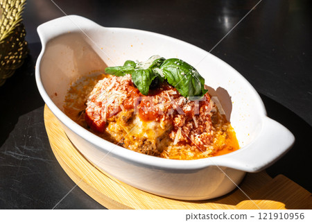 Lasagna portion, oven baked lasagne, pasta layers with cheese, minced meat, tomato in sunny summer day 121910956