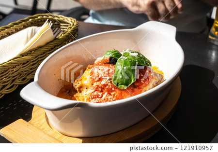 Lasagna portion, oven baked lasagne, pasta layers with cheese, minced meat, tomato in sunny summer day Lasagna portion, oven baked lasagne, pasta layers with cheese, minced meat, tomato in sunny summer day 121910957