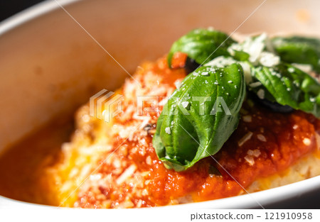 Lasagna portion, oven baked lasagne, pasta layers with cheese, minced meat, tomato in sunny summer day 121910958