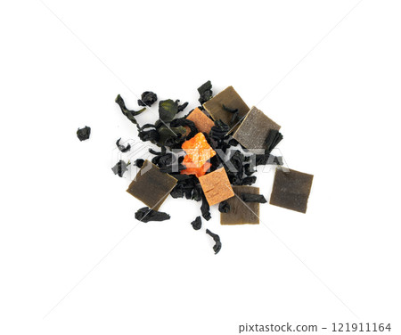 Dry kelp seaweed squares, mini wakame pieces isolated, dried kombu and carrot flakes from ramen Dry kelp seaweed squares, mini wakame pieces isolated, dried kombu and carrot flakes from ramen 121911164