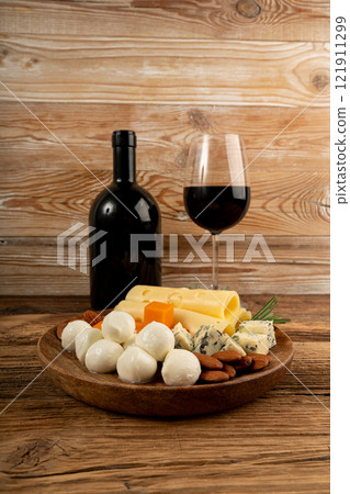 Cheese plate of color cheeses variety, yellow, white and blue gorgonzola platter with red wine glass Cheese plate of color cheeses variety, yellow, white and blue gorgonzola platter with red wine glass 121911299