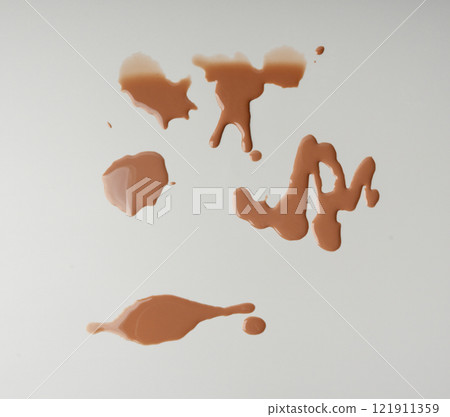 Spilled chocolate milk, hot chocolate puddle, liquid stain, coffee splatter, brown latte with on grey Spilled chocolate milk, hot chocolate puddle, liquid stain, coffee splatter, brown latte with on grey 121911359