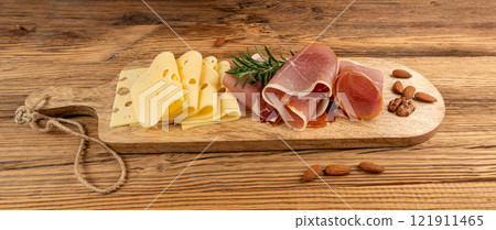 Cheese plate with prosciutto, jamon cut, parma ham, serrano slices, cured iberico closeup, cheese board Cheese plate with prosciutto, jamon cut, parma ham, serrano slices, cured iberico closeup, cheese board 121911465
