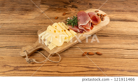 Cheese plate with prosciutto, jamon cut, parma ham, serrano slices, cured iberico closeup, cheese board Cheese plate with prosciutto, jamon cut, parma ham, serrano slices, cured iberico closeup, cheese board 121911466