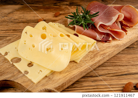 Cheese plate with prosciutto, jamon cut, parma ham, serrano slices, cured iberico closeup, cheese board 121911467