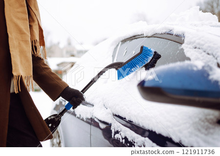 Portrait of smiling man cleaning snow off his car during winter snowfall. Transport, weather concept 121911736