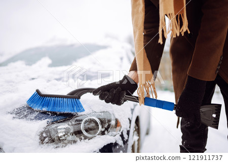 Portrait of smiling man cleaning snow off his car during winter snowfall. Transport, weather concept 121911737
