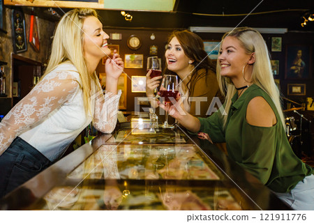 Girls with alcohol glasses in pub club 121911776