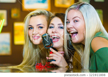 Women singing with microphone 121911808