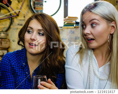 Girls in pub club gossiping and talking 121911817