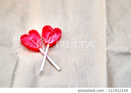 Representation of love through two red lollipops shaped like a red heart. 121912149