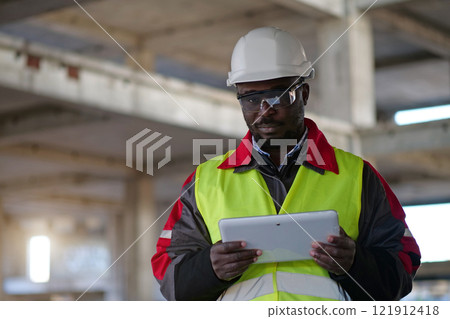 African american worker holds in hands tablet computer and looks at camera African american worker holds in hands tablet computer and looks at camera 121912418