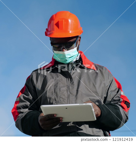 African american workman holds in hands white tablet computer African american workman holds in hands white tablet computer 121912419