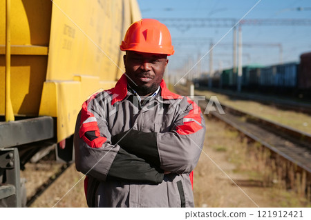 Railroad man in uniform and red hard hat look at the camera 121912421