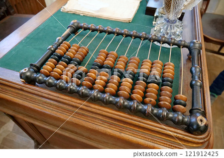 Old abacus, counting frame lies on the table in office 121912425