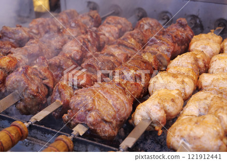 Kebabs on skewers are grilled on hot coals Kebabs on skewers are grilled on hot coals 121912441