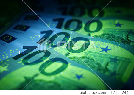 Security signs and elements on euro banknotes glow under ultraviolet light 121912443