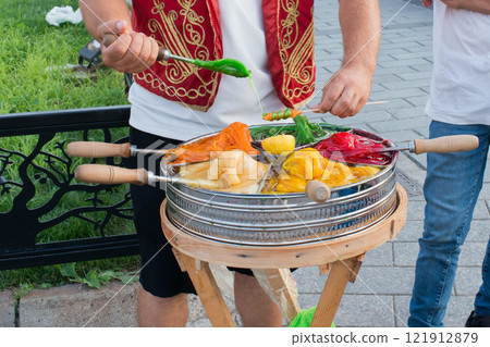 Market vendor cooking macun, turkish toffee in traditional container for colorful caramel lollipops. Street food in Istanbul, Turkey 121912879