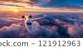 Private jet airplane flying above clouds in sunset 121912963
