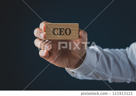 Businessman showing a wooden identity card with the word CEO on it 121913121