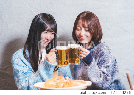 Two young women toasting in front of a crab hotpot [Photo courtesy of Seafood Izakaya Gyoruko] 121913256
