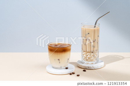 Two glasses iced coffee latte with alternative milk on a yellow and blue background 121913354