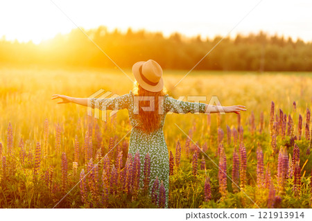 A beautiful woman with a bouquet of lupins, collects flowers, inhales fresh floral air. A beautiful woman with a bouquet of lupins, collects flowers, inhales fresh floral air. 121913914