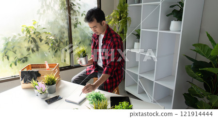 Innovative Plant Enthusiast Using Tablet for Efficient Indoor Plant Management 121914444
