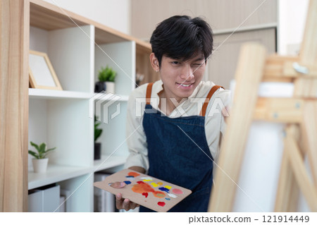 Creative young artist painting in modern studio indoor setting inspirational atmosphere close up perspective Creative young artist painting in modern studio indoor setting inspirational atmosphere close up perspective 121914449