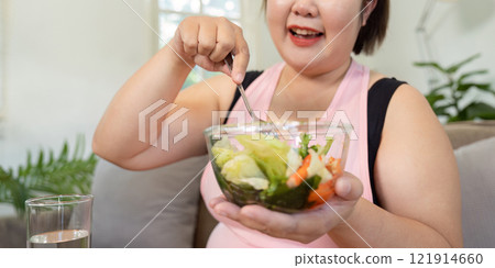 Healthy eating journey overweight woman enjoying fresh food to lose weight in a cozy home setting Healthy eating journey overweight woman enjoying fresh food to lose weight in a cozy home setting 121914660