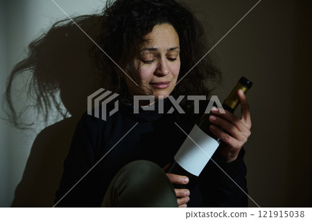 Woman in Emotional Distress Holding Alcohol Bottle Woman in Emotional Distress Holding Alcohol Bottle 121915038