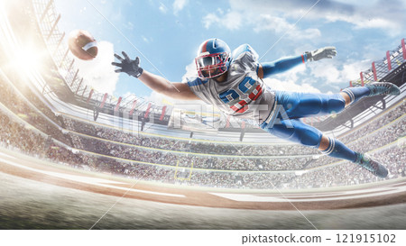 Football. Sportsman in action. Player catches the ball and flies in the air. Professional sports background for advertisement with lights, fans and flags 121915102
