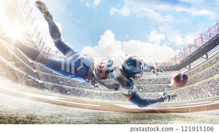 American football. Player catches the ball and flies in the air. Back view. Sportsman in action. Professional stadium with lights and fans 121915106