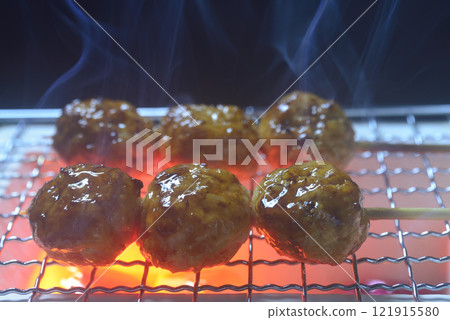 Grilling chicken meatballs on a charcoal grill with smoke rising Grilling chicken meatballs on a charcoal grill with smoke rising 121915580