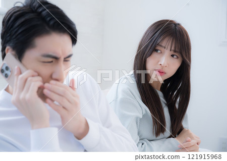 Husband and wife feel awkward after receiving a work call on a holiday morning Husband and wife feel awkward after receiving a work call on a holiday morning 121915968