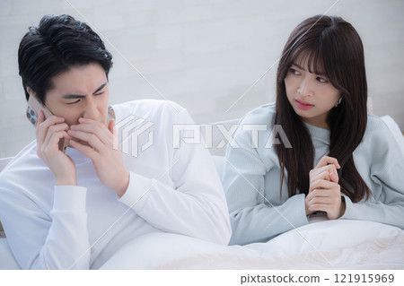 Husband and wife feel awkward after receiving a work call on a holiday morning Husband and wife feel awkward after receiving a work call on a holiday morning 121915969