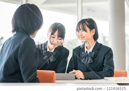 小學生、國中生、高中生、高中女生（朋友）在學校上課時與坐在後面的學生交談。 121916525