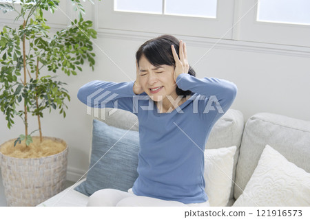 女人摀住耳朵，50 多歲，噪音問題，客廳 121916573
