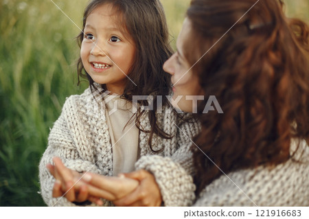 Family in a summer field. Sensual photo. Cute little girl in a knited sweater. 121916683