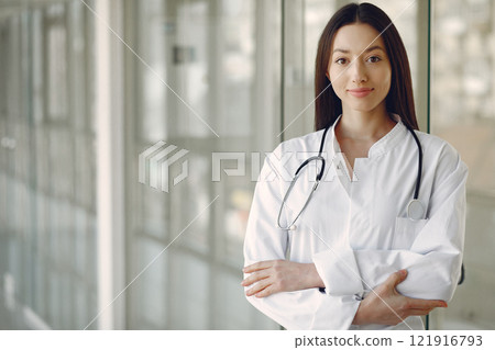 Woman in a uniform. Doctio with a stethoscope. Brunette in a hall. 121916793
