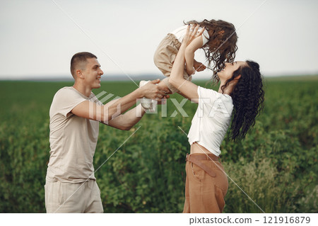 Family walks in a field. Little girl child in the summer meadow. Woman in a white shirt. Family walks in a field. Little girl child in the summer meadow. Woman in a white shirt. 121916879