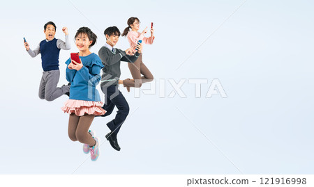 A full-body photo of a three-generation family, with a child jumping while using a smartphone 121916998