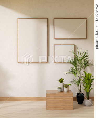 Minimalist picture frames are mounted on a white wall in a room featuring indoor plants. 121918792