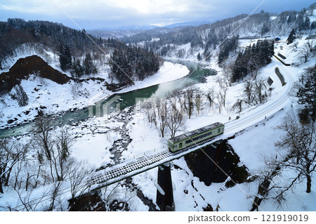 飯山線上的當地列車穿過白雪千曲川沿岸的鐵路橋 121919019