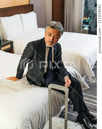 Middle-aged male business person relaxing in bed 121919441