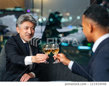 Multinational business people toasting with the city night view in the background Multinational business people toasting with the city night view in the background 121919446