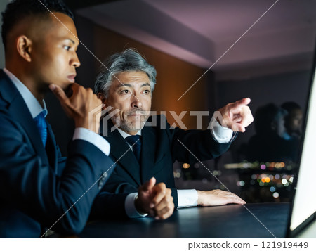 跨國商人晚上在辦公室看著螢幕開會 121919449